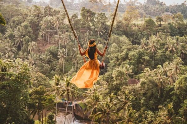 Young woman swinging in the jungle rainforest of Bali island, Indonesia