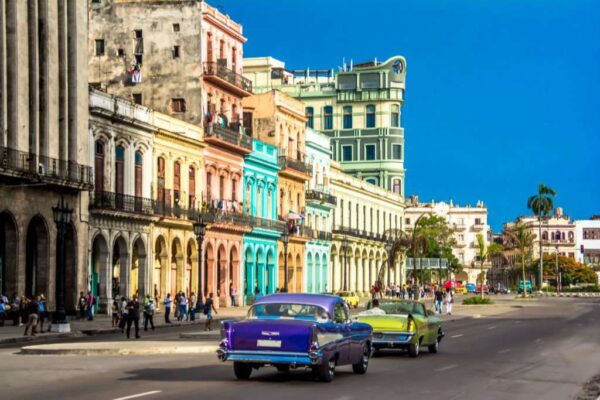 View of downtown Havana city with old classic cars and people walking on the street, Cuba.