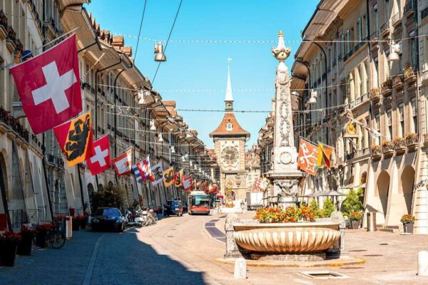 Street view on Kramgasse with fountain and clock tower in the old town of Bern city